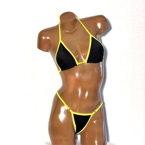 May include: Black bikini with yellow trim. The top is a triangle style and the bottom is a cheeky cut.