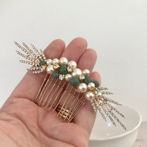 K&ouml;nnte beinhalten: Goldener Haarkamm mit einem Cluster aus Kunstperlen und gr&uuml;nen Perlen. Der Kamm hat ein dekoratives Design mit Strasssteinen.