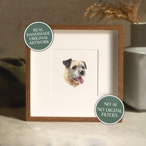 May include: A framed watercolour portrait of a dog with a light brown and black coat, tongue out. The artwork is in a wooden frame with a white mount. Text on the frame reads "REAL HANDMADE ORIGINAL ARTWORK" and "NO AI NO DIGITAL FILTERS".