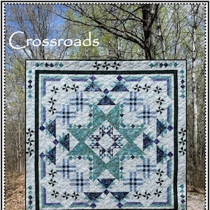 May include: A quilt pattern called "Crossroads" by Whirligig Designs. The quilt is made with a variety of blue, green, and white fabrics. The quilt is displayed against a backdrop of trees and a dirt road.
