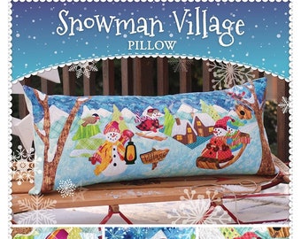 May include: A colorful patchwork pillow featuring a winter scene with snowmen, a house, and a sled. The pillow is titled "Snowman Village Pillow" and is made by Shabby Fabrics.