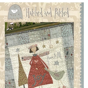 May include: A quilted wall hanging with a whimsical design. The artwork features a figure in a red dress with the word "JOY" and the text "Peace to All". The design includes a Christmas tree and a bird holding a banner that says "LOVE".