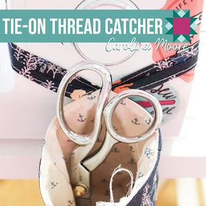 May include: A black and white fabric thread catcher with a tie-on strap. The catcher is filled with white thread and a pair of silver scissors. The fabric has a pattern of anchors and a floral design. The text "TIE-ON THREAD CATCHER" and "Carolina Moore" is printed on the top of the image. A barcode is printed on the bottom of the image.