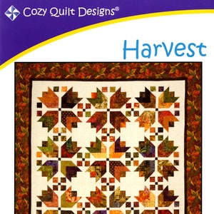 May include: A quilt pattern titled "Harvest" by Cozy Quilt Designs. The quilt design features a repeating pattern of stylized leaves in shades of orange, brown, and green. The pattern is designed for 2.5" strips and includes wall hanging, throw, twin, queen, and king sizes.