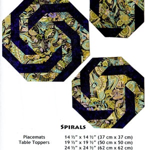 May include: A quilting pattern called "Spirals" with instructions for making placemats and table toppers in two sizes: 14 1/2 inches by 14 1/2 inches and 19 1/2 inches by 19 1/2 inches. The pattern uses a dark blue and gold fabric with a paisley design.