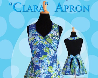 May include: A blue and green floral print apron with a V-neck and a tie at the waist. The apron is called "Clara" and is a women's version of the "Claire" apron. The pattern number is RRD 312 and it was designed by Rebecca Anderson.