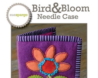 May include: Purple felt needle case with a colorful embroidered bird and flower design. The case measures 6 1/2 inches by 8 1/2 inches.