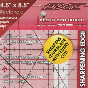May include: A 4.5 inch by 8.5 inch clear plastic rectangle ruler with a red grid system and black diagonal lines. The ruler has a yellow circle with the text "Sharpens your blade with every cut!" and the text "The Cutting Edge" in red. The ruler is labeled "Sharpening Edge" and has the number "4" on the right side.