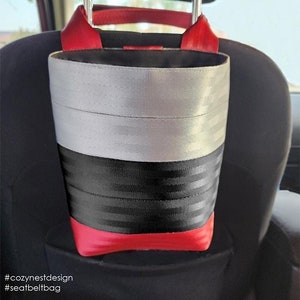 May include: A red, black, and gray car seat trash bag kit. The kit is made from seat belts and hangs from the back of the front seats or the side of the center console. The kit is available in two sizes: small (9 x 10 x 4 inches) and large (10 1/2 x 10 x 4 inches).