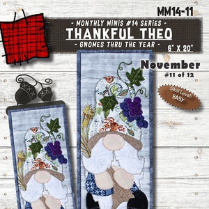 May include: A Thanksgiving gnome quilt pattern featuring a gnome with a pumpkin and corn. The pattern is part of the "Thankful Theo - Gnomes Thru the Year" series, and is titled "November". The pattern is 6 inches by 20 inches and is labeled as "Easy" skill level.