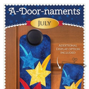 May include: A-Door-naments July door hanger with a blue background and red, yellow, and blue stars. The door hanger is designed to be hung on a door knob. The image also shows an additional display option for the door hanger.
