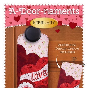 May include: A-Door-naments February door hanger with a red, pink, and white heart design. The hanger features a bow and the word "Love" in white embroidery. An additional display option is included.