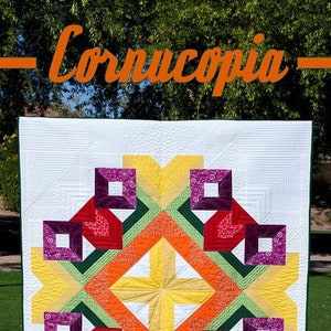 May include: A quilt pattern called "Cornucopia" with a colorful geometric design featuring shades of red, orange, yellow, green, and purple. The pattern includes instructions for a throw or queen size quilt.