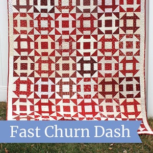 May include: A red and white quilt with a "Fast Churn Dash" pattern. The quilt is hanging on a clothesline outside. The quilt is made with a variety of red and white fabrics. The quilt is labeled "Amy Smart Diary of a Quilter".