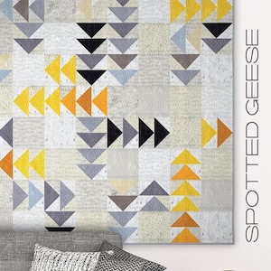May include: A quilt pattern featuring a geometric design of gray, black, yellow, and orange triangles. The quilt is titled "Spotted Geese" and is displayed on a wall above a gray couch with pillows. The text "Zen Chic" is displayed on a white square below the couch.