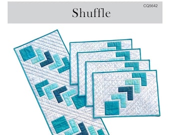 May include: A quilting pattern for a table runner and placemats. The pattern features a geometric design with blue and white squares. The runner is 14 1/2 inches by 50 1/2 inches and the placemats are 13 1/2 inches by 18 1/2 inches. The pattern is called "Shuffle" and is from Canuck Quilter Designs.