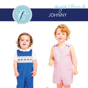 May include: Two children wearing blue and pink overalls with white shirts. The boy on the left is wearing a blue overall with a white shirt and a red and white embroidered design. The boy on the right is wearing a pink overall with a white shirt. The boys are standing in front of a wooden abacus with colorful beads.