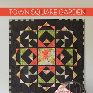 May include: A quilt pattern called "Town Square Garden" by Color and Quilt, designed by Robin Pickens. The quilt features a black background with a geometric pattern of red, green, and white fabric. The quilt is available in two sizes: 38 x 38 inches and 54 x 54 inches.