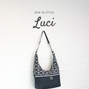 May include: A black and white patterned shoulder bag with a silver chain strap. The bag has three zippers and the text "Luci" is written above the bag. The text "Sew in Style" is written above the text "Luci". The text "Sallie Tomato" is written below the bag. The text "Your source for quality sewing patterns & purse supplies" is written below the text "Sallie Tomato".