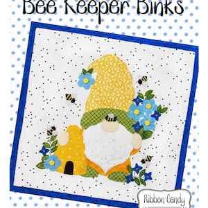 May include: A colorful quilt block featuring a gnome with a yellow hat, a beehive, and bees. The block is surrounded by a blue border and a white background with blue polka dots. The text "Gnome-Mania!! August Bee Keeper Binks" is at the top of the image. The text "Ribbon Candy Quilt Company" is at the bottom of the image.