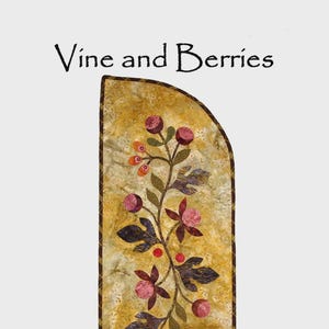 May include: A decorative table runner with a floral vine and berry design. The runner features a yellow background with appliquéd leaves, flowers, and berries in shades of purple, pink, and orange. The finished quilt size is 32" x 12".