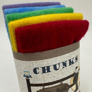 May include: A set of six colorful yarn skeins in shades of purple, blue, green, yellow, and red. The skeins are wrapped in brown paper with the text "CHUNKS In The Patch DESIGNS" printed on the label.