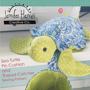 May include: A handmade sea turtle pin cushion and thread catcher sewing pattern. The turtle has a green and white polka dot head and flippers, and a blue and white patterned shell. The thread catcher is green with white polka dots.