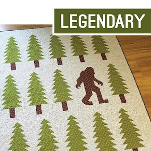 May include: A quilting pattern for a lap quilt and floor pillow featuring a Bigfoot silhouette in a forest of green trees. The pattern is by Elizabeth Hartman and includes instructions for a 60" x 72" lap quilt and a 26" x 26" floor pillow.