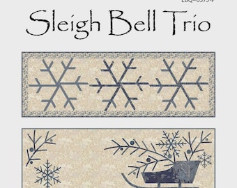 May include: A fabric panel featuring three winter-themed quilt designs. The top panel displays three snowflakes, the middle panel shows a sleigh with snowflakes, and the bottom panel has Christmas trees and snowflakes. Each quilt is 44" x 15".