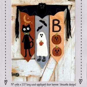 May include: A Halloween door banner with a black cat, ghost, and pumpkin design. The banner is 19 inches wide and 25 inches long. The banner is made of wool and is appliqued. The banner is titled "#448 Spooky Friends Door Banner".