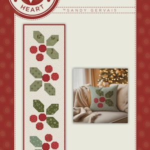May include: A holiday-themed design featuring a repeating pattern of red berries and green leaves on a cream background. The design is displayed on a table runner and a pillow, with the text "Holly-day Cheer".
