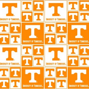 May include: A repeating pattern featuring the University of Tennessee logo. The design includes the letter "T" in orange and white squares, with the words "University of Tennessee" printed below the "T" in some squares. The background is white.