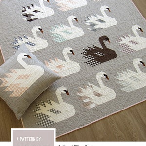 May include: A quilt pattern featuring a gray background with white swans and a black swan. The pattern includes instructions for three quilt sizes and a quilted pillow cover. The pattern is titled "Swan Island" and is by Elizabeth Hartman.