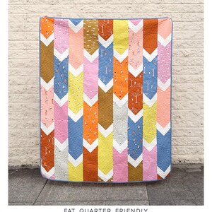 May include: A colorful quilt pattern called "The Verity Quilt" with a chevron design. The quilt is made with fat quarters and is available in baby, lap, twin, queen, and king sizes. The quilt is made by Kitchen Table Quilting.