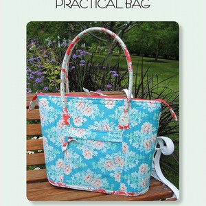 May include: A quilted tote bag with a floral pattern in shades of blue, pink, and white. The bag has a red zipper and handles with a matching floral design. The bag is 18 inches wide, 12 inches deep, and 14 inches tall. Text on the image reads "Aunties Two Patterns A Perfectly Practical Bag."