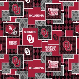 May include: A red, black, and gray fabric with a repeating pattern of the Oklahoma Sooners logo, the words "Oklahoma" and "Boomer Sooner", and a wagon with the word "Sooners" on it.