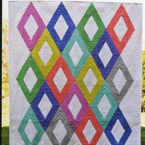 May include: A colorful quilt with a repeating diamond pattern in shades of pink, yellow, blue, green, orange, and gray. The quilt has the text "Girl's Best Friend" at the top and the "Swirly Girls" logo at the bottom.