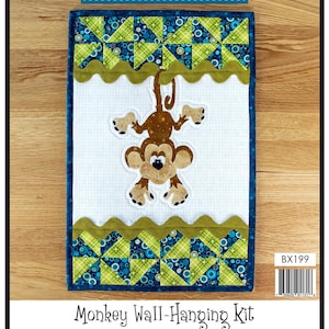 May include: A monkey wall hanging kit with a brown monkey applique hanging from a green and blue patchwork border. The kit includes instructions, precut fused applique and templates, fabric, and notions for wall-hanging. Finished size: 12 1/2" x 19". Leanne Anderson 2024.