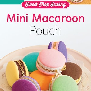 May include: Six colorful fabric pouches shaped like macarons, each with a zipper closure. The pouches are arranged on a white plate with a lace pattern.  "Sweet Shop Sewing Mini Macaroon Pouch" is written in pink letters on a white background.