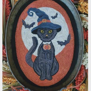 May include: A decorative oval tray featuring a black cat wearing a witch hat and a pumpkin collar, surrounded by bats. The design is set against a white and orange background. The text "Practical Magic Punch" is at the bottom.