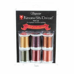 May include: Six spools of Superior Threads #100 Kimono Silk Thread in fall colors. The spools are labeled "Fall Collection" and are packaged in a clear plastic container.