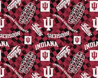 以下が含まれることがあります： 「インディアナ」、「フーシャーズ」、および「インディアナ大学」の文字が白で繰り返されるパターンで、赤と黒のチェック柄の背景があります。インディアナ大学のロゴが含まれています。全体的なテーマは大学です。