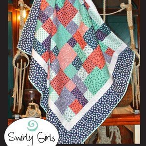May include: A quilt pattern called "Snappy" by Swirly Girls Design. The quilt is made up of squares in shades of blue, green, pink, and white. The quilt is 60 inches by 66 inches. The pattern is called a "dashing bobbin" pattern.