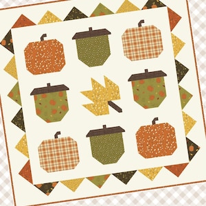 May include: A 30" x 30" autumn-themed quilt featuring a cream background with orange pumpkins, green acorns, and a yellow leaf. The quilt is bordered with triangles in fall colors and includes the text "HELLO Autumn" and "PRIMROSE COTTAGE".
