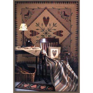 May include: A cozy, rustic interior scene featuring a quilted wall hanging with heart and bird motifs. A wooden rocking chair is draped with a striped blanket. A small table holds a lamp and a basket filled with items. A heart-themed rug completes the scene.