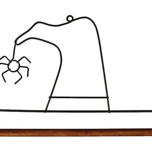 May include: Black metal wire witch hat hanger with a wooden dowel rod. A small spider is attached to the hat.