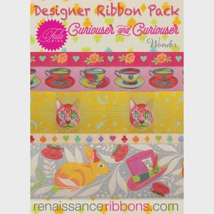 May include: Designer ribbon pack with various Alice in Wonderland themed designs. Ribbons feature teacups, cat faces, and the Mad Hatter's hat. The text "Curiouser and Curiouser" is visible.