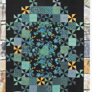 May include: A quilt pattern featuring a central design of a peacock surrounded by a border of teal, blue, and gold pinwheels. The pattern is titled "Grand Central" and is by "Swirly Girls".