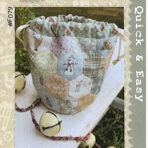 May include: A Christmas treat bag sewing pattern with a patchwork design featuring a snowman, a Christmas tree, and presents. The pattern is titled "Hatched and Patched" and "All for Christmas Treat Bag".