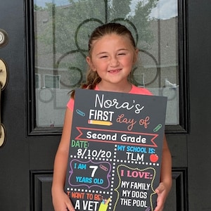 Shows child holding a milestone chalkboard sign that is reusable to document milestones for the first and last day of school.